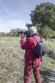 photographer  in action with camera in nature