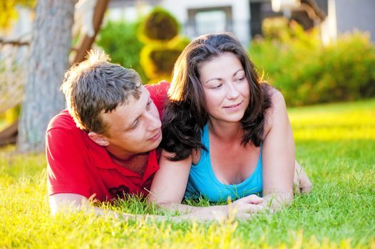 Young couple lying on the grass, and that it is considering