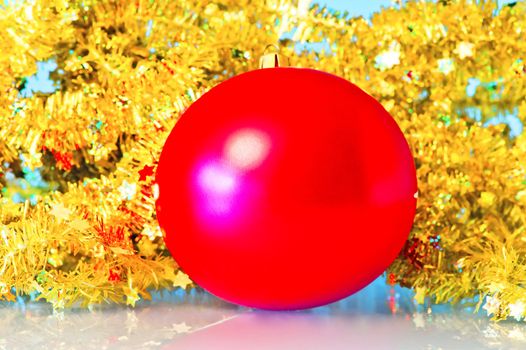 Red Christmas ball in a golden tinsel