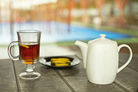 Cup of tea on the wooden table at the pool