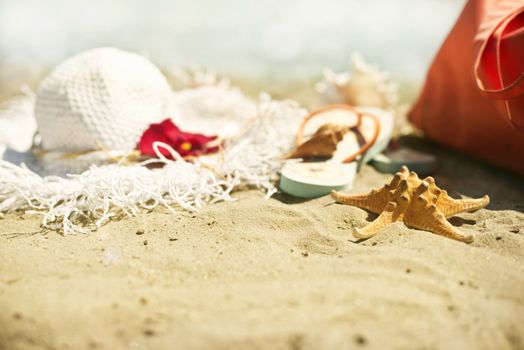 Collection of beach items - seastar, flip-flops, sunglasses and hat