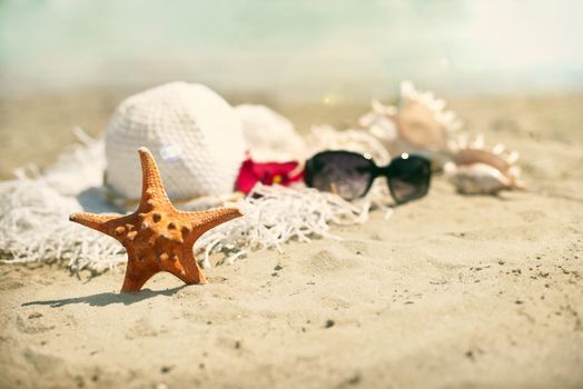 Collection of beach items - seastar, flip-flops, sunglasses and hat