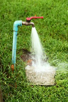 Tab water flowing out from ball valve to the ground in field