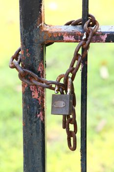 Antique and rusty key and chain on old iron fence