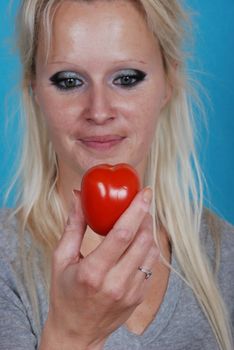 Blond womanl eating a tomato