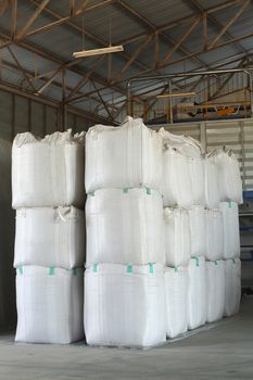 stack of big bag contain rice in warehouse
