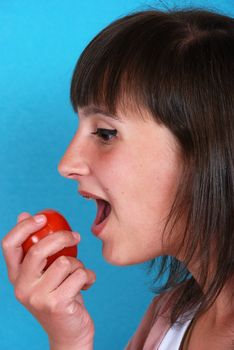 Girl eating a tomato