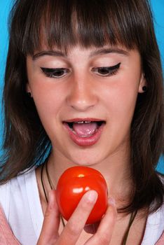 Girl eating a tomato
