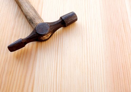 Closeup of a pein hammer head on a wooden background with copy space