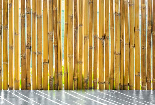 Yellow bamboo fence and concrete floor