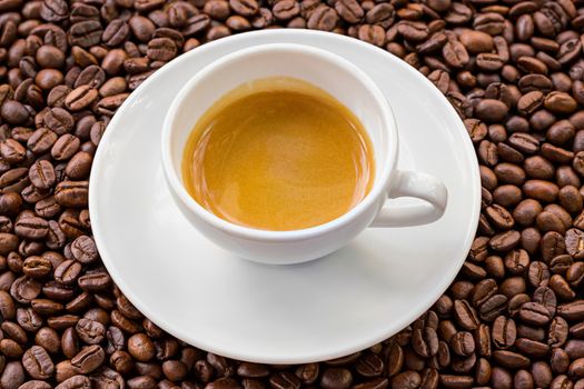 Espresso with golden crema and coffee bean background