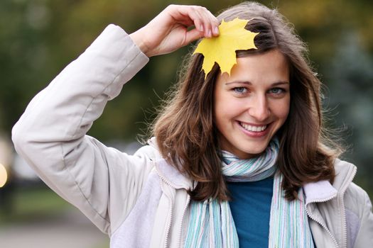 young beautiful woman with a bouquet of maple leaves