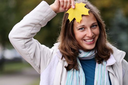 young beautiful woman with a bouquet of maple leaves