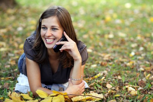 woman calling by phone in autumn park