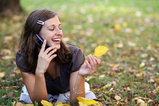 woman calling by phone in autumn park