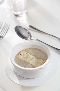 A serving of mushrooms cream soup  in a restaurant.