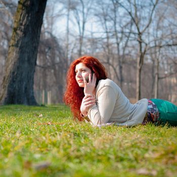 beautiful young woman on the phone in the park