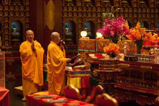 SINGAPORE - SEP 08: Monk chanting in Buddha tooth relic temple on Sep 08, 2013 in Singapore. Since opening in 2007, the temple has become a popular attraction within Chinatown.