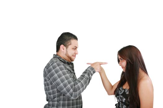 Young couple pointing at each other against a white background