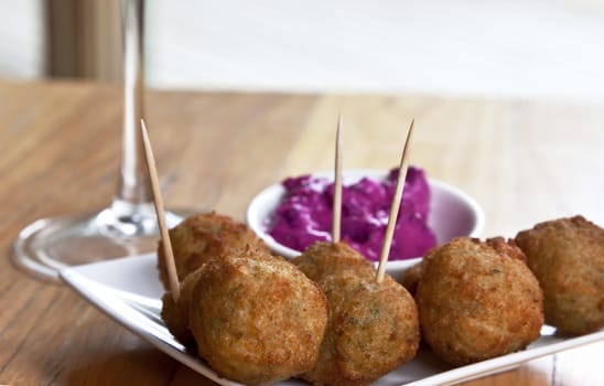 Fried hummus balls served as appetizers with beet root dip; location is on Mornington Peninsula, outside Melbourned, Victoria, in Australia. Hummus, with a Middle Eastern origin, is made from chickpeas