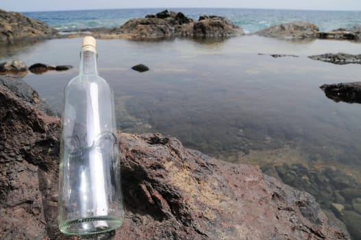 Message in the Bottle on the Rocks near the Beach