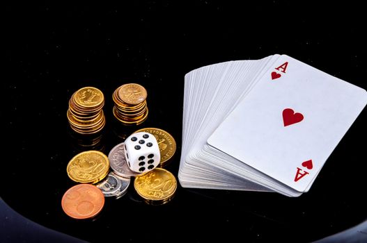 An image of playing cards, dice and money