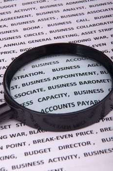 An image of magnify glass over paper with written business slang