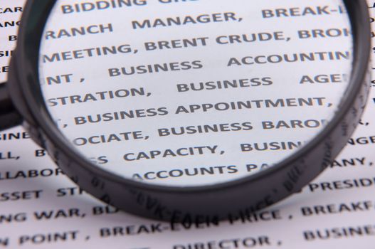 An image of magnify glass over paper with written business slang