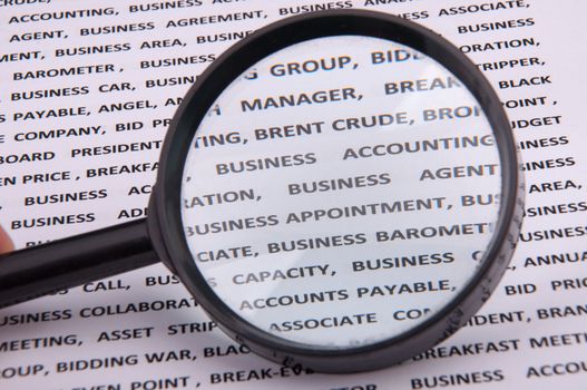 An image of magnify glass over paper with written business slang