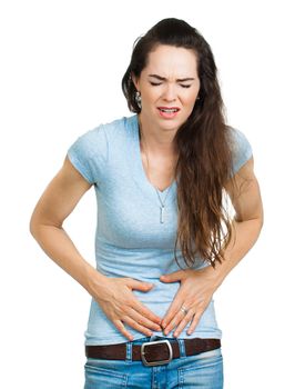 A woman suffering from bad tummy cramps and pains. Isolated on white.