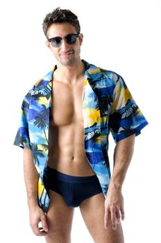 Attractive, muscular young man smiling, wearing open hawaian style shirt, swimming suit and sunglasses