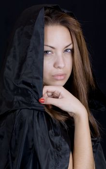 Dramatic portrait of a young lady in a black cape, may-be a young witch