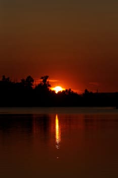 Colorful sunset over tranquil water surface.