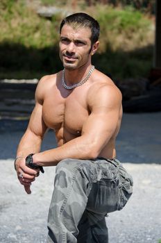 Muscle man shirtless outdoors in building site resting after construction work