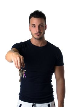 Handsome young man holding bunch of keys, looking in camera, isolated on white