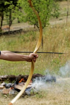 archery man shooting arrow with bow in the nature