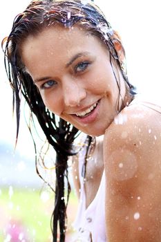 Young happy woman wet in the rain
