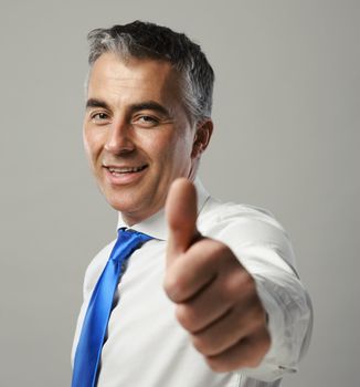 Happy mature business man showing thumbs up sign