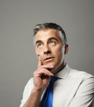 Mature business man looking up and thinking about something
