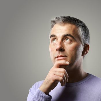 Portrait of casual man thinking and looking up