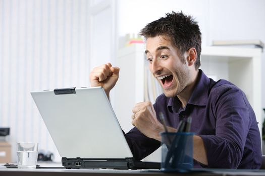 Young student happy after she saw the good news in front at laptop