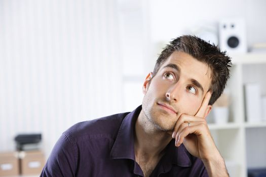 Portrait of a casual young man looking up, copy space