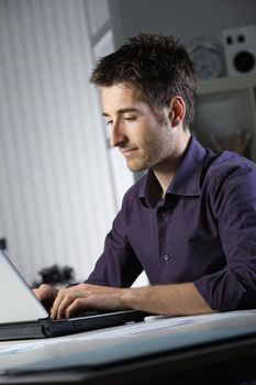 Young man at home working on laptop