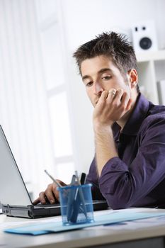 Young man at home working on laptop