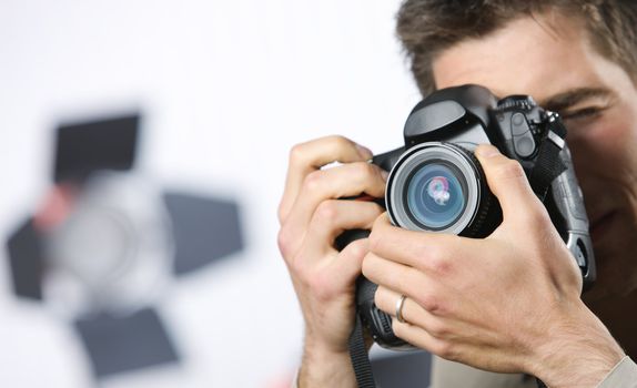 Young man taking photo with professional digital camera