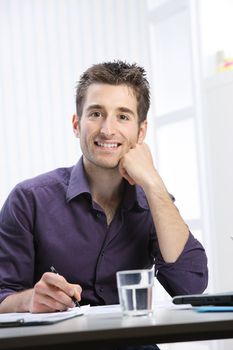 Portrait of a young man working at desk