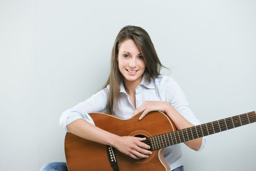 Portrait of smiling young woman with her guitar