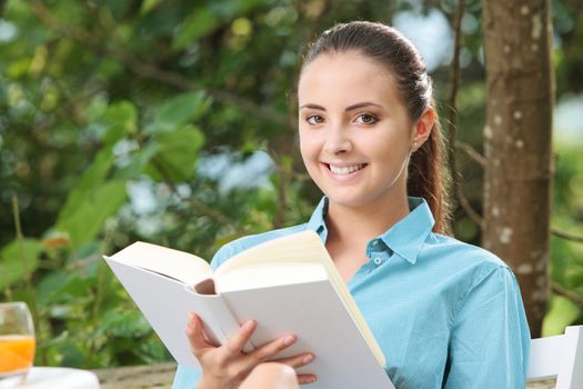 Portrait of Beautiful girl reading a book outdoors