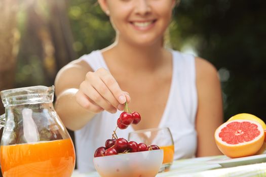 Close up of female hand takes a cherry