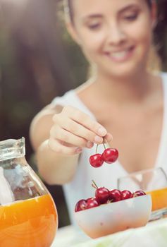 Close up of female hand takes a cherry